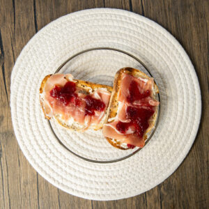 Close-up of artisan toast topped with ricotta and cranberry spread